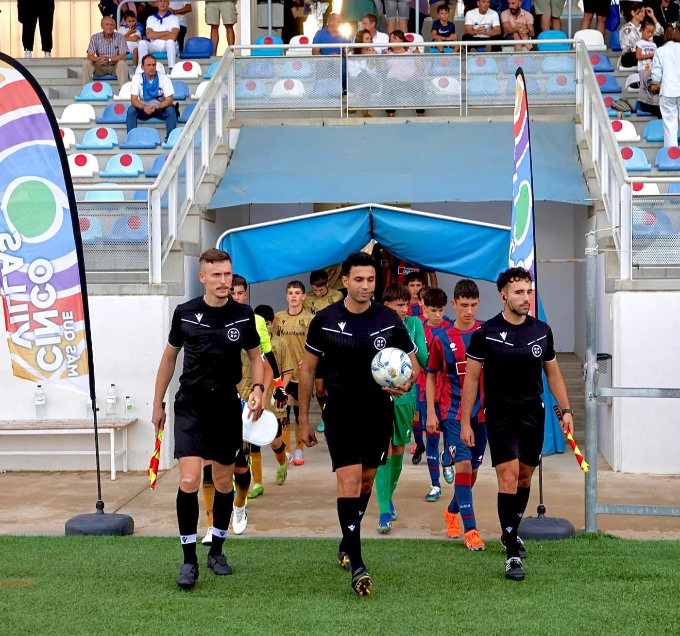 Equipo arbitral saliendo al terreno de juego